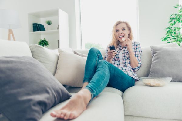 mejores-series-cuarentena-mujer-feliz-en-el-sofa-istock